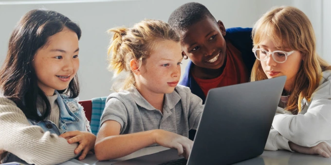Children looking at a laptop together at school